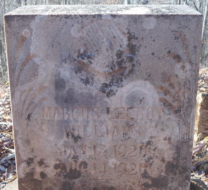The moss on the head stone of this baby resembles a mother holding a child.